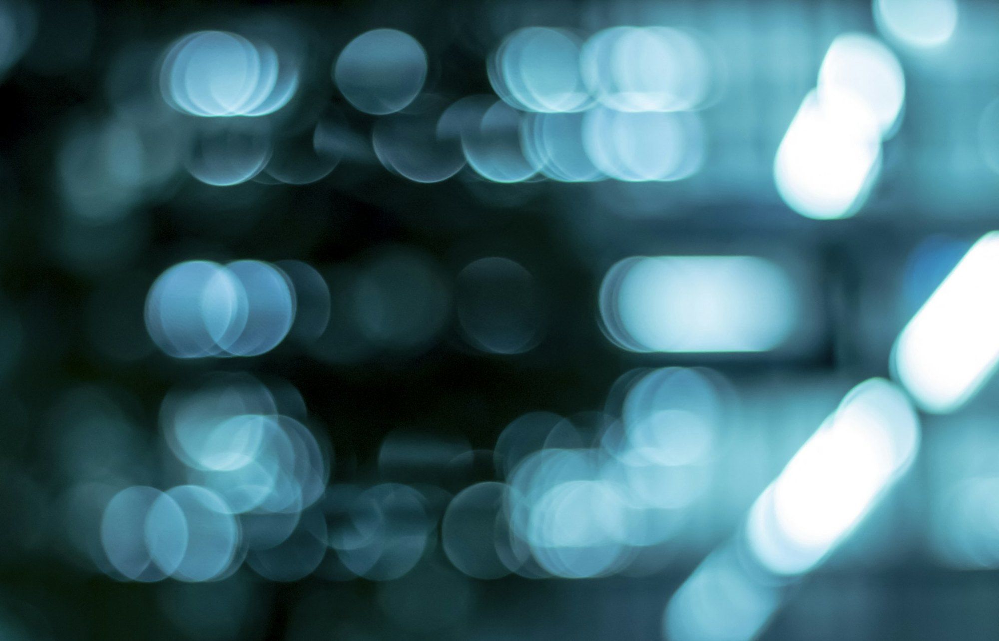 Bluish lights out of focus, like the indicator lights of equipment seen blurred