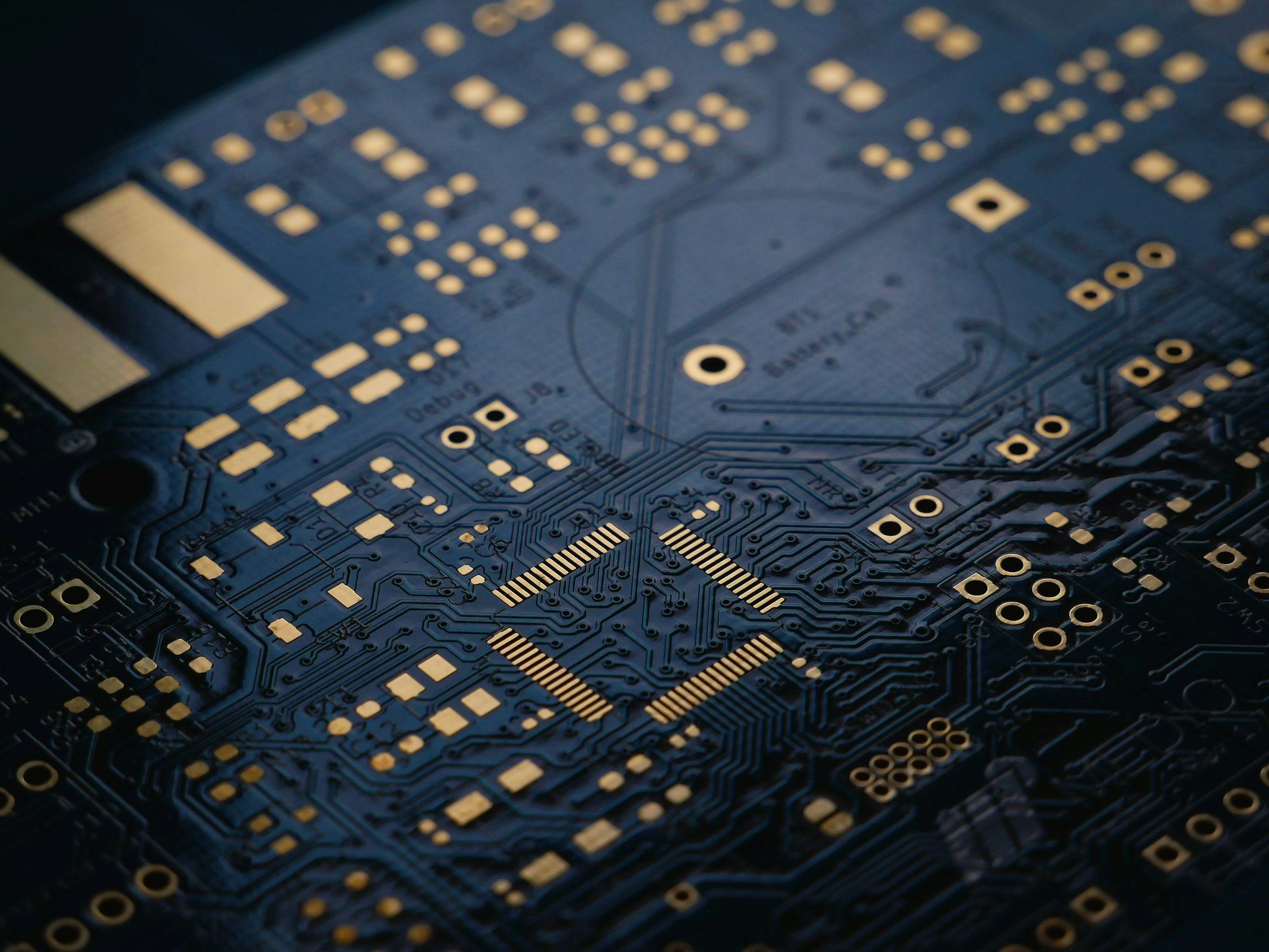 Dark blue printed circuit board without components, with gold tracks and contacts